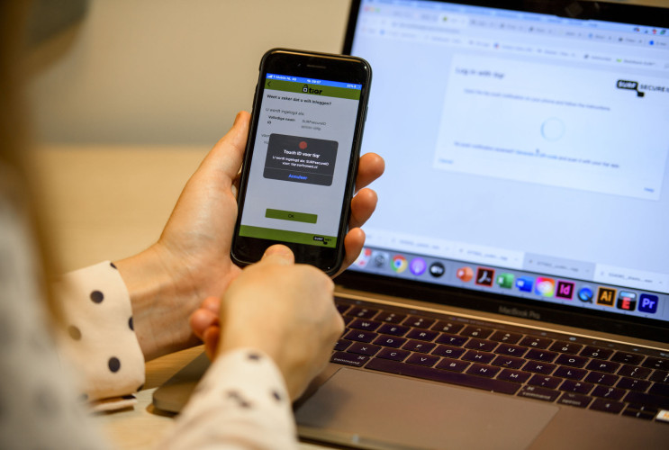 Iemand logt in met haar vingerafdruk middels de Tiqr-applicatie op haar telefoon