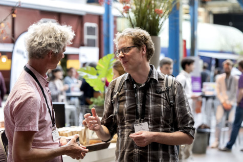 Mensen die praten bij het netwerkplein op SURF Research Day 2023