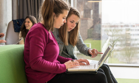 Twee studentes kijken samen naar een laptop