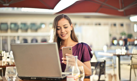 Vrouw in paars met laptop en smartphone