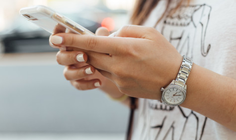 Een vrouw die een telefoon in haar handen heeft.