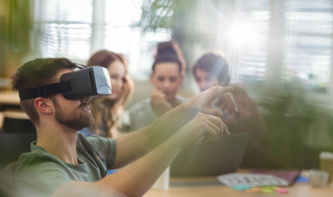 Man met VR-bril op en vrouwen in de achtergrond