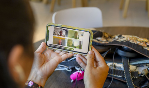 Student kijkt op het beeldscherm naar een videogesprek met meerdere deelnemers