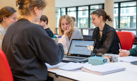 four female students are smiling on their laptops