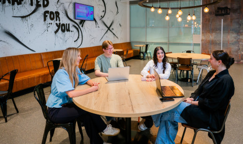 vier mbo studenten van aventus zitten aan een ronde tafel en zijn in gesprek