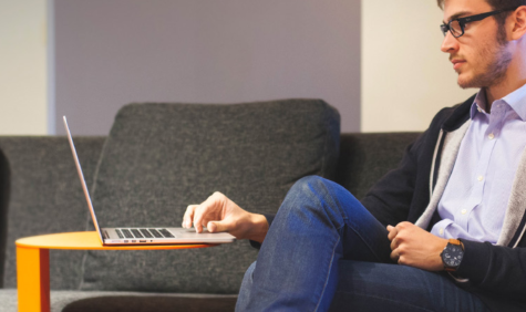 student achter laptop op de bank