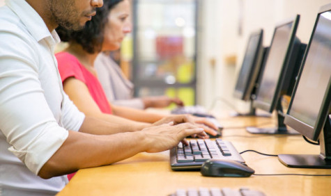 personen achter desktop scherm