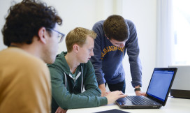 Drie studenten achter een laptop