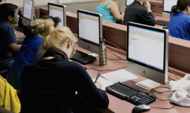 Studenten in collegezaal achter computers