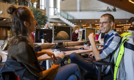 Student en medewerkers zitten tafel in gebouw Forum van Wageningen Universiteit