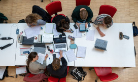 Bovenaanzicht van 6 studenten die samen studeren aan een lange tafel