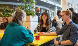 drie personen in gesprek aan een tafel