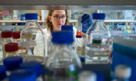student kijkt naar reageerbuis in een chemielab