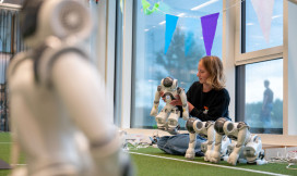 Studente zit op de grond en is met een robot aan het werk