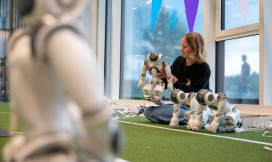 Studente zit op de grond en is met een robot aan het werk