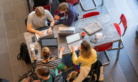 Bovenaanzicht werkplekken op de UVA met studenten