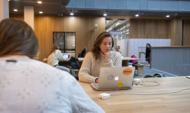 Studente op laptop aan het werk in de hal van de VU