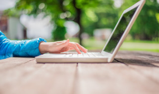 Vrouw buiten achter laptop