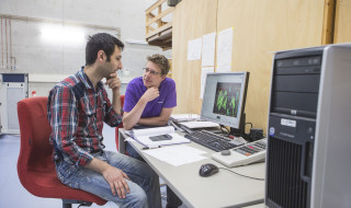 Twee onderzoekers samen achter computer kijken naar data