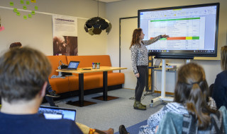 Student presenteert onderzoek op scherm aan klas