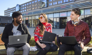 Studenten buiten op een bankje met laptops