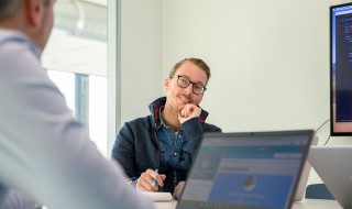 volwassenen in gesprek met laptop