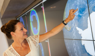 Vrouw wijst op scherm met visualisatie van zeestromingen