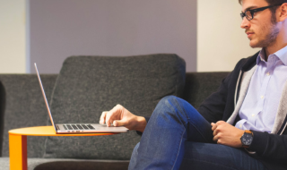 student achter laptop op de bank