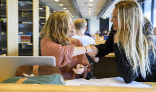 twee studentes schudden elkaar de hand SURF