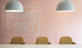 Afbeelding van SURF kantoor, drie stoelen met de tekst op de achtergrond "Have a seat"
