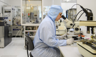 onderzoeker achter een microscoop in een lab