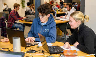 studenten werken samen achter laptop