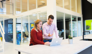 Man legt iets uit aan vrouw op laptop