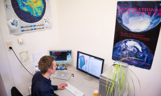 Leo van Kampenhout aan zijn bureau achter de computer