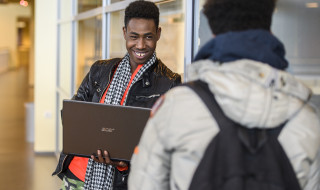 Foto van 2 studenten met een laptop