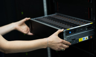 Vrouw pakt rack uit supercomputer Snellius