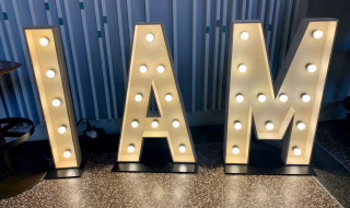 Foto van lichtletters die het woord IAM vormen