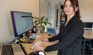 Ana Verbanescu staand achter computer