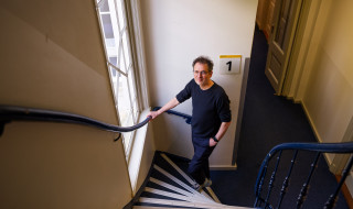 Antal van den Bosch onderaan trap kijkt naar boven