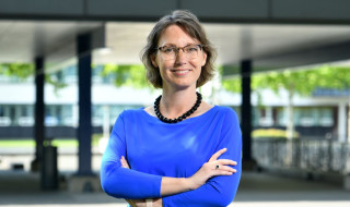 Portret Universiteit Twente-bestuurder Machteld Roos in een blauwe jurk