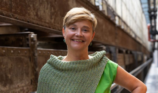 Portret ROC van Twente-bestuurder Trudy Vos tegen een industriële omgeving