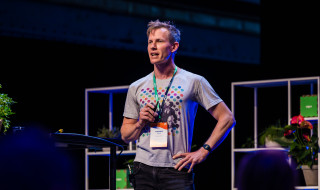 Thomas Wolf spreekt op het podium bij Pydata in amsterdam