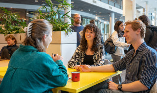 drie personen in gesprek aan een tafel