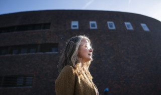 Nolda in front of the typical round brick building of the RUG's Zernike campus