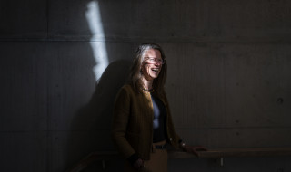 Nolda against the same shadow wall but now she is smiling