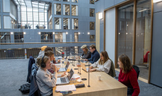 Studenten werken samen aan een lange tafel