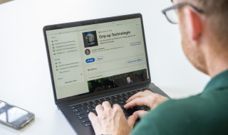 Kees Verhoeven op de rug gezien werkend achter laptop