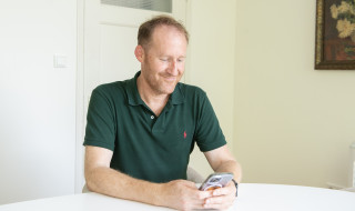 Kees Verhoeven kijkt op zijn mobiele telefoon