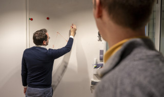 Tom Emery schrijft iets op een whiteboard