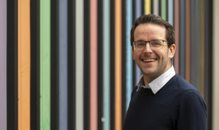 Tom Emery kijkt lachend de camera in